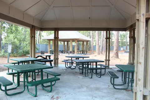 Covered picnic pavilion with green picnic tables