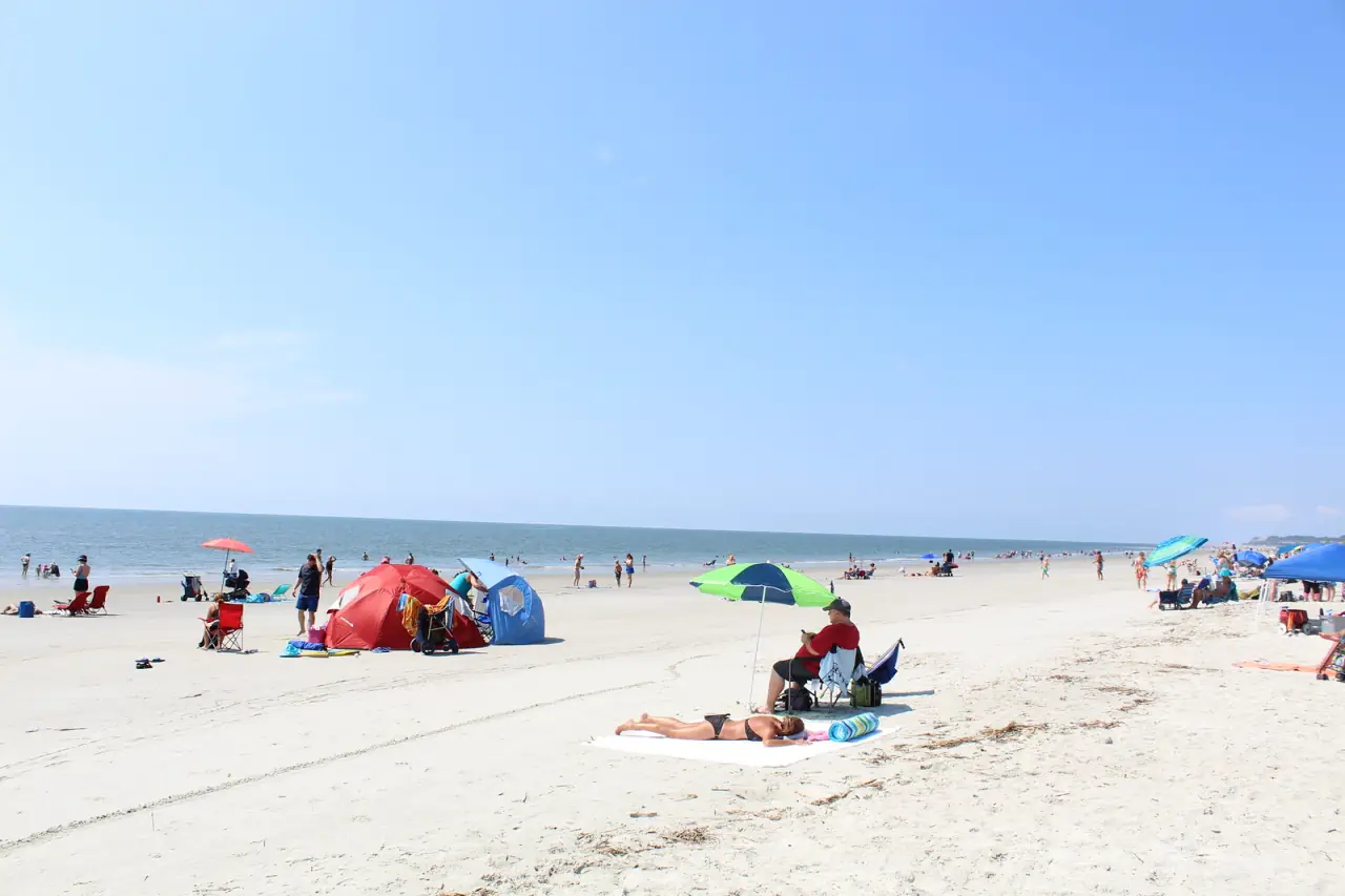 Beachgoers with tents and umbrellas on a sunny, crowded beach at Driessen Beach Park, Hilton Head Island