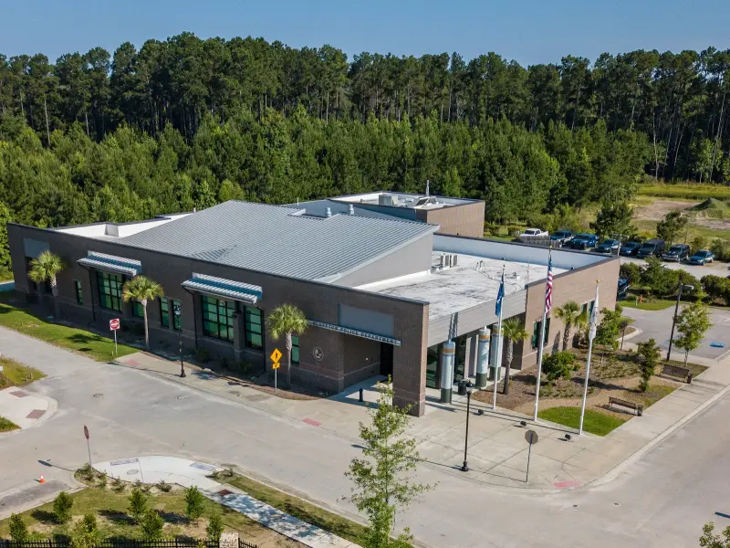 An aerial view of the Bluffton Police Department headquarters, a low brick building with flagpoles