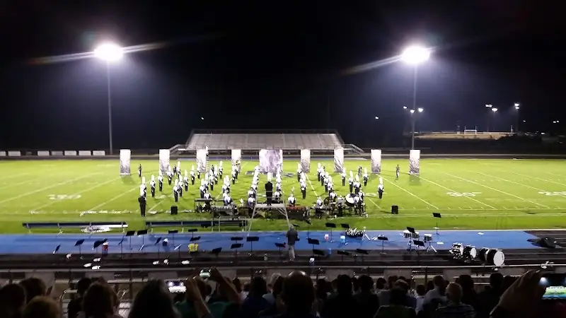 A marching band on the lit football field at May River High School at night