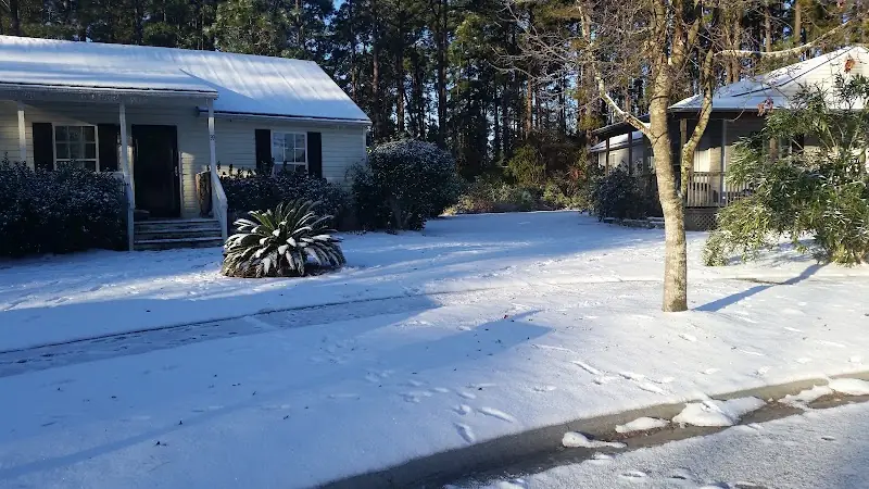 The Sparklight store on Fording Island Road in Bluffton, its lawn and palmettos under a rare snowfall