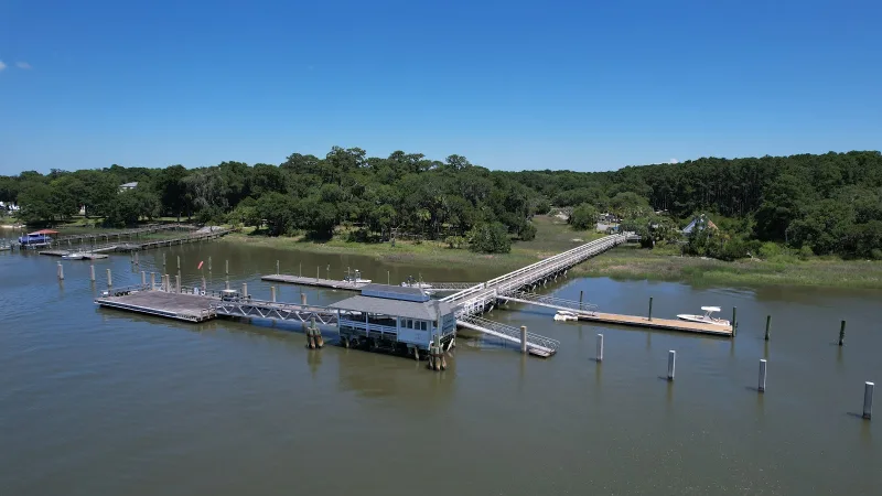 An aerial view of Freeport Marina on Daufuskie Island, its long dock reaching into the creek from the trees