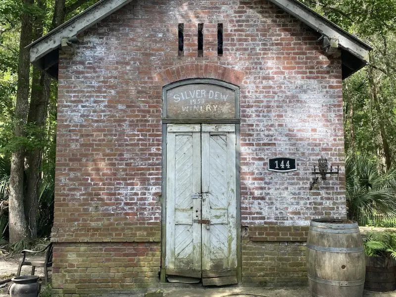 The small brick oil house of the Bloody Point Lighthouse, painted Silver Dew Winery over its double doors
