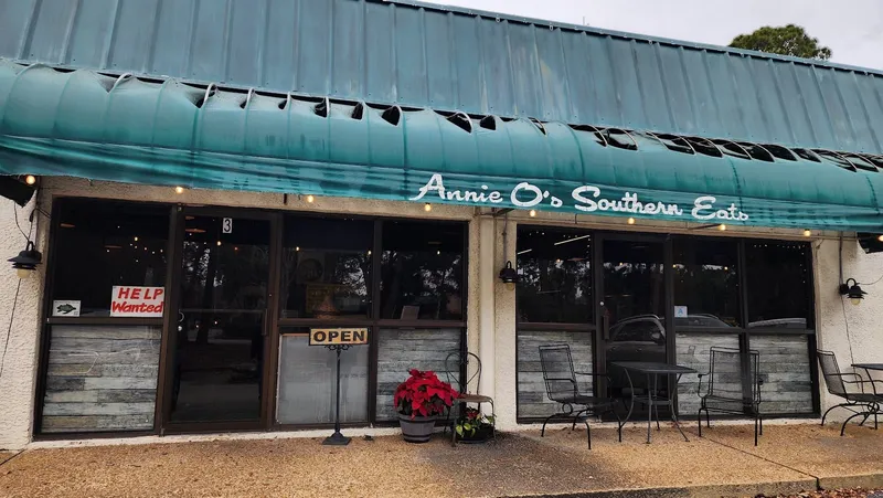 The storefront of Annie O's Kitchen with its teal awning and outdoor tables