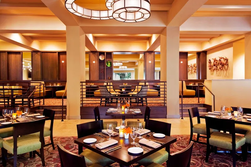 The Carolina Room dining room at the Westin, with set tables, booths and warm lighting