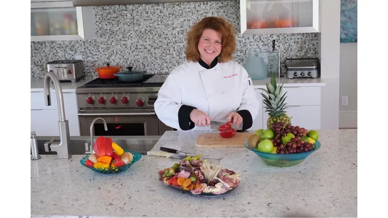 Chef Lynn Michelle in chef whites cutting fruit at a rental home kitchen island