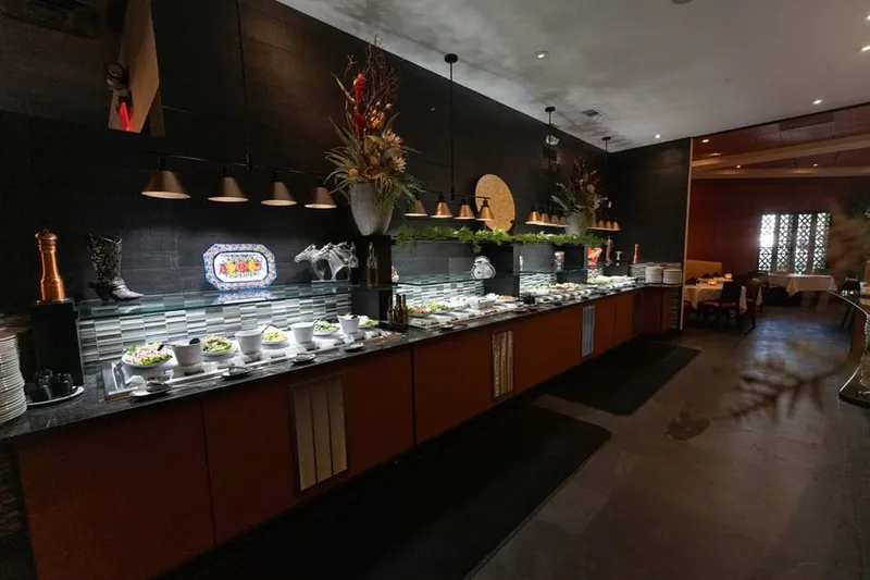 The long salad and hot bar at the Brazilian steakhouse on William Hilton Parkway, with pendant lights over the counter and the dining room behind it