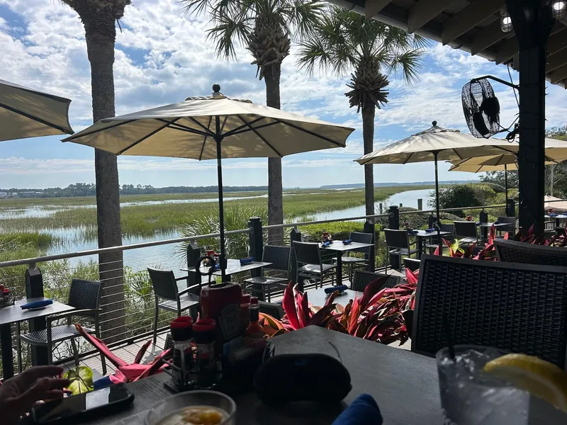 The outdoor deck at The Crazy Crab Jarvis Creek, with tables and umbrellas over the marsh