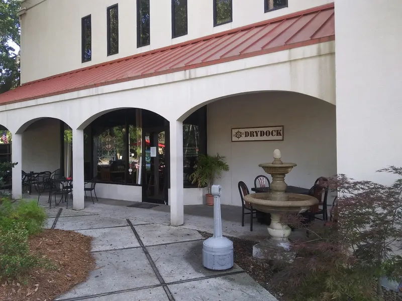 The DryDock storefront on William Hilton Parkway, with a covered arcade, outdoor tables and the DryDock sign by the door