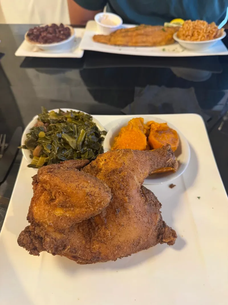 A plate of fried chicken with collard greens and candied yams at Good Soul Southern Kitchen