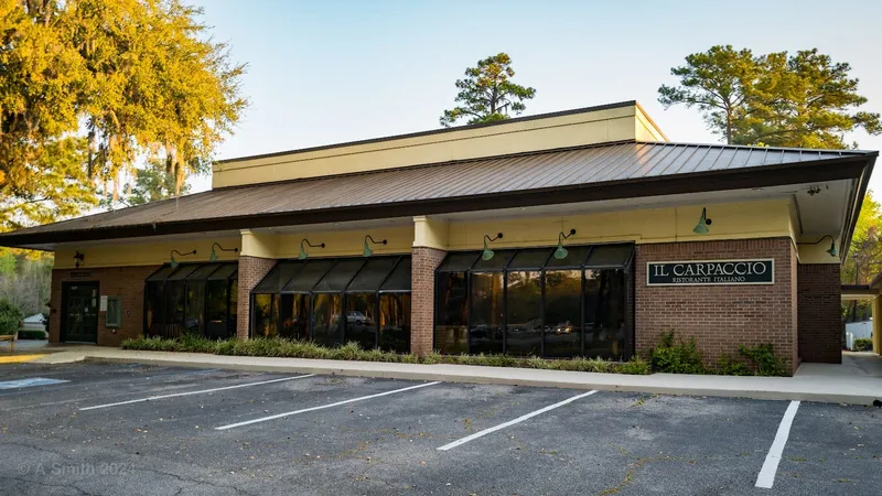 Il Carpaccio's brick storefront and sign with its parking lot in front