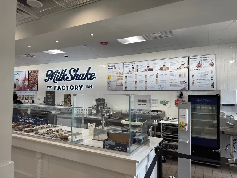 The counter and menu boards inside MilkShake Factory, with the chocolate case at the left