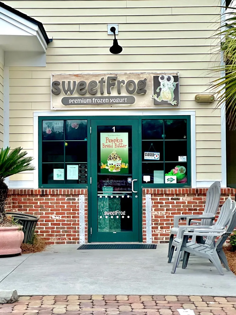 The sweetFrog storefront in the Office Park Road plaza, with the sweetFrog sign above a green door and a brick base