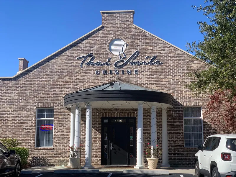 The brick storefront of Thai Smile Cuisine with its sign over the entrance