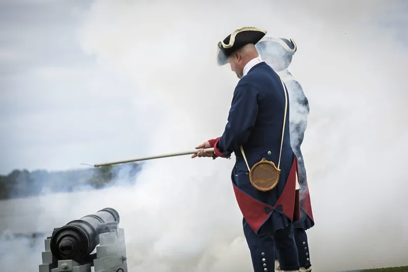 A man in colonial uniform firing a cannon salute at the RBC Heritage opening ceremony