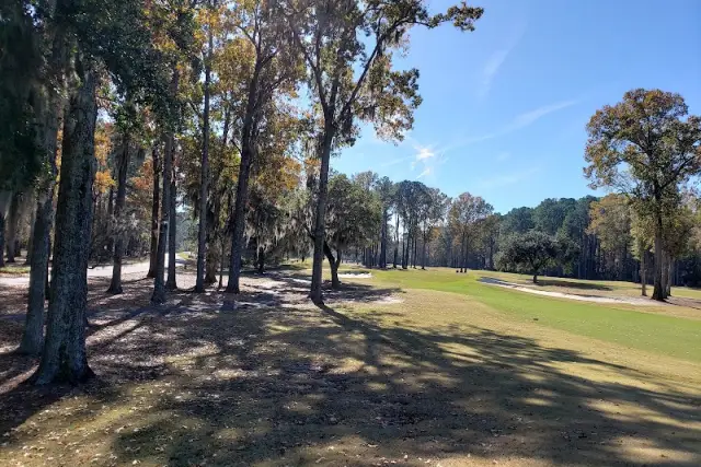A fairway and bunker seen from under a stand of oaks and pines at Callawassie Island Club