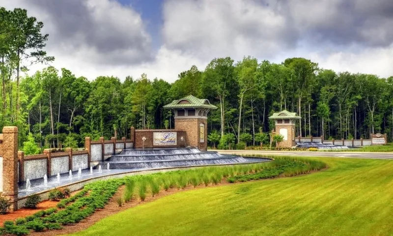 The Hilton Head Lakes entrance: a long stone wall and fountain between two tower gatehouses, pines behind