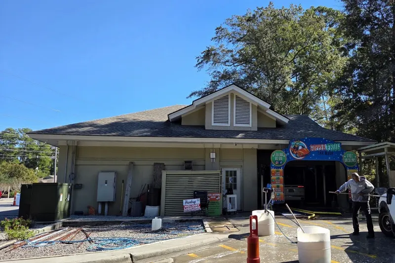 The Copper Frog Car Wash building and wash bay among the pine trees