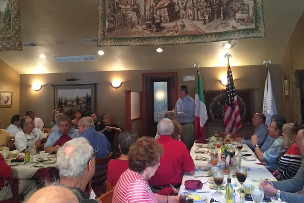 Members at an Italian American Club luncheon, with the Italian and American flags at the front of the room