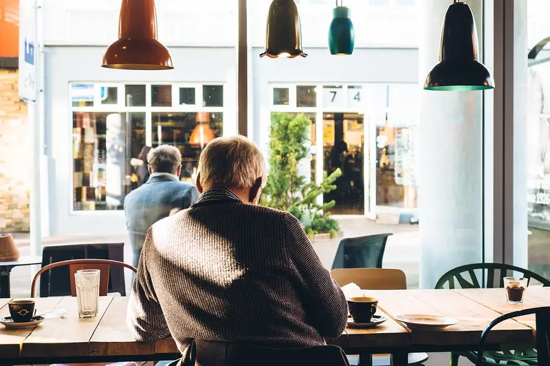 A man reading the paper over tea in a café