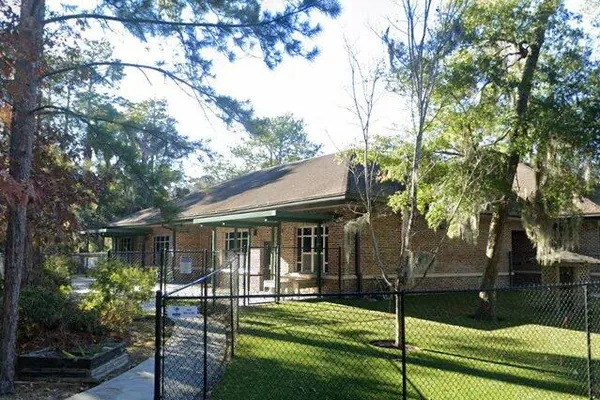 The brick classroom wing and fenced lawn of the Hilton Head Island Early Childhood Center