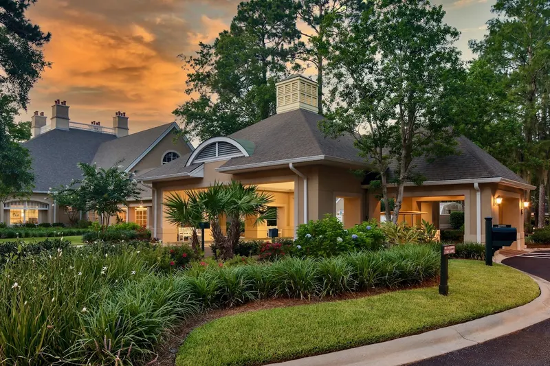 The Cypress of Hilton Head clubhouse at sunset behind a planted bed