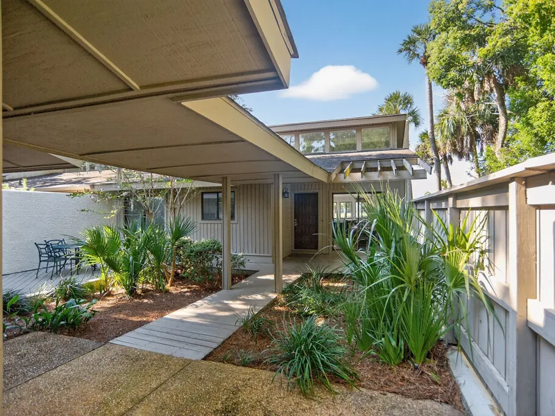 A covered walkway through a planted courtyard at Fairway One in Sea Pines