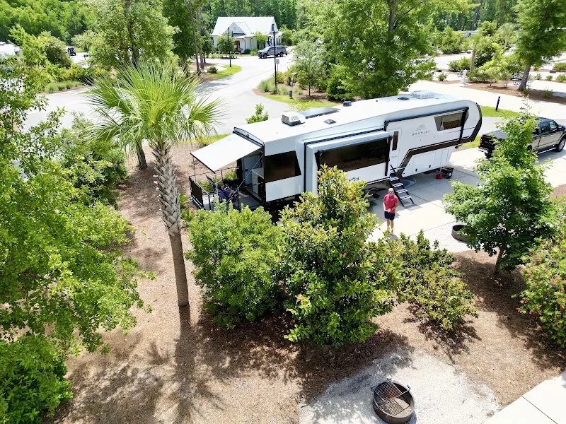 A fifth-wheel RV at a landscaped site at Hilton Head National RV Resort