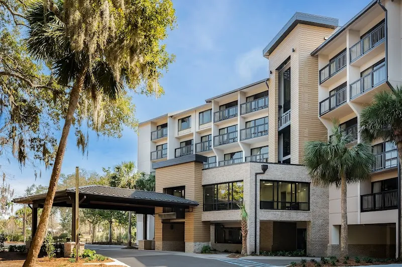 The Holiday Inn Express Hilton Head Island, a five-story hotel with a covered entrance under live oaks