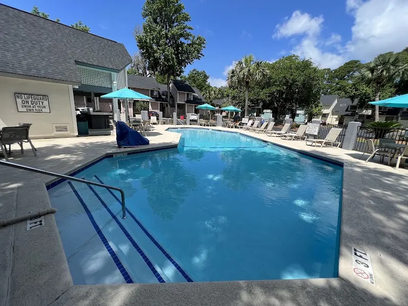 The pool at Palmera Inn & Suites, with loungers and the hotel building behind