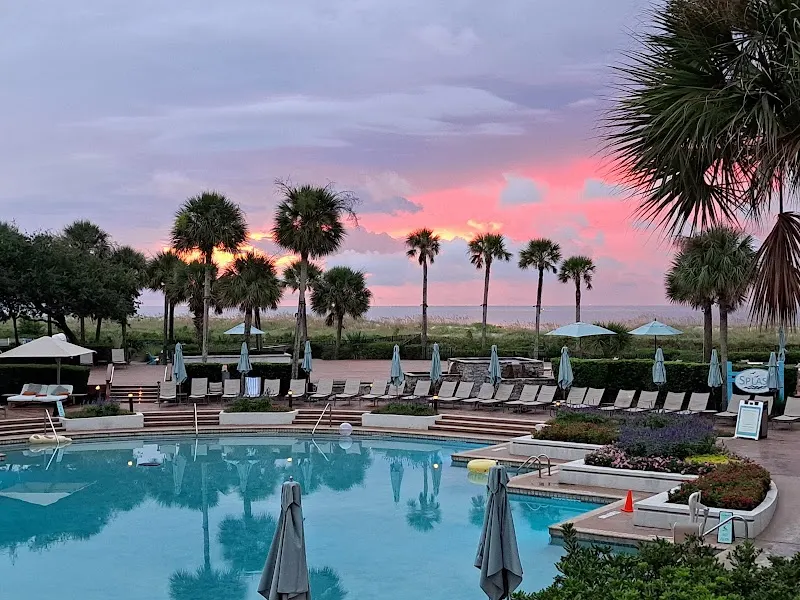 The pool at the Westin Hilton Head Island Resort at sunset, with palms and the beach beyond