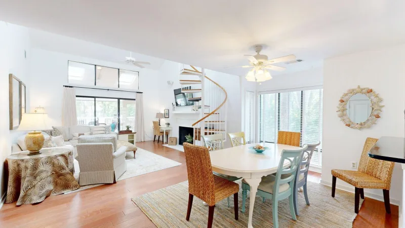 Two-story living room with a spiral staircase in a Captains Cove townhome