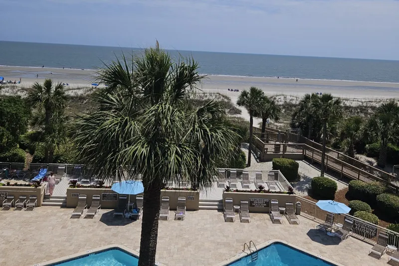 View from an upper floor of Captain’s Walk over the pool and boardwalk to the beach