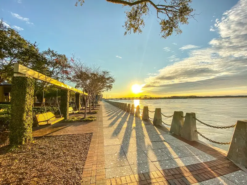 The promenade of Henry C. Chambers Waterfront Park in Beaufort, with the sun low over the Beaufort River