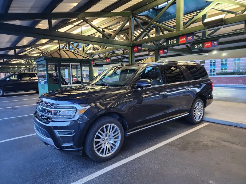 A black SUV rental under the steel canopy of the Savannah airport rental lot