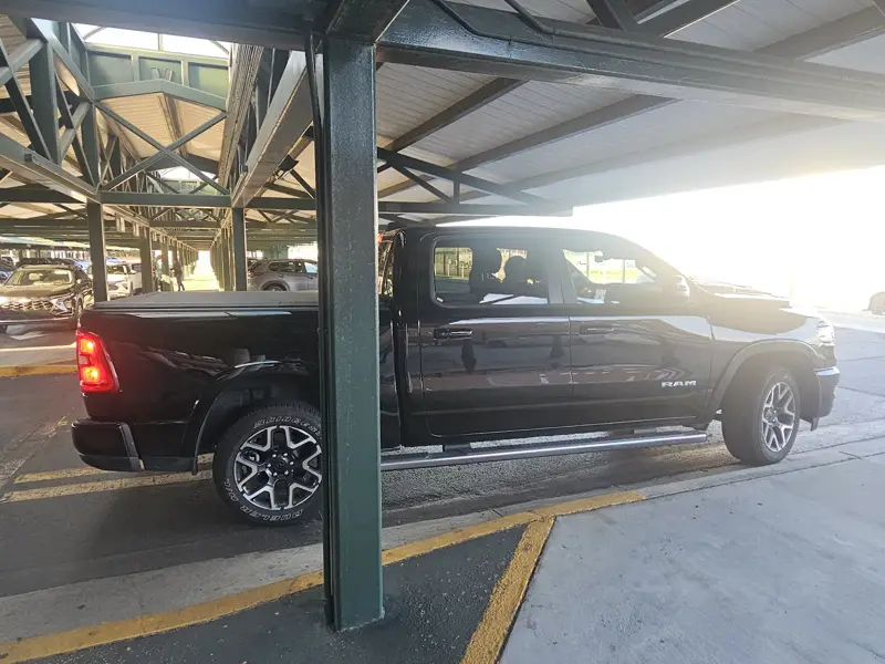 A black pickup truck rental under the steel canopy of the Savannah airport rental lot