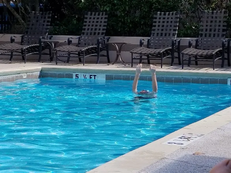 A pool at Brighton Bay Villas on Hilton Head Island, with lounge chairs along the far side