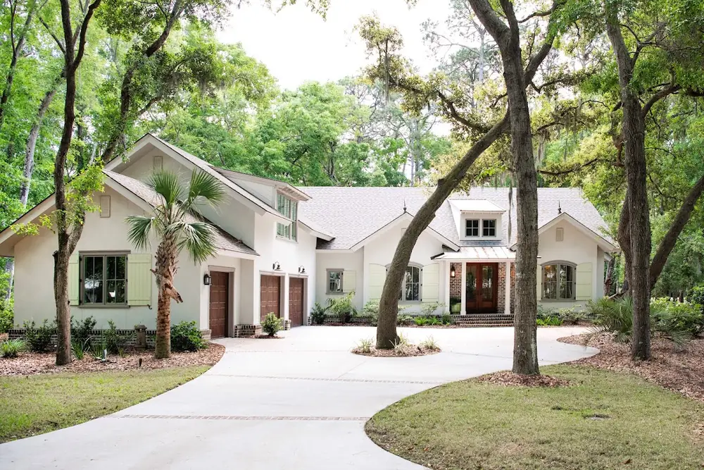 A white Lowcountry house with a curved driveway under live oaks on Hilton Head Island