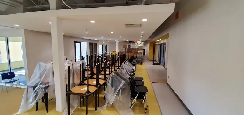 Furniture wrapped in plastic and lined up in a storage warehouse