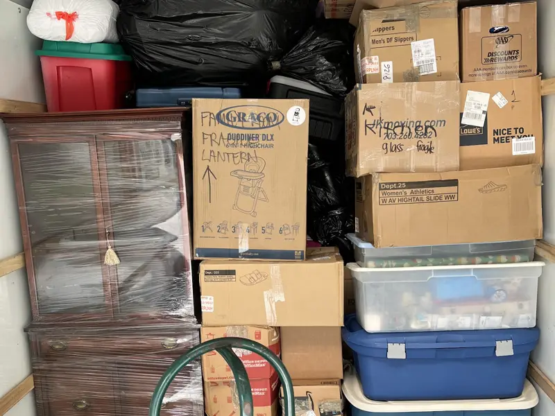 Boxes, bins and furniture packed tightly into the back of a moving truck