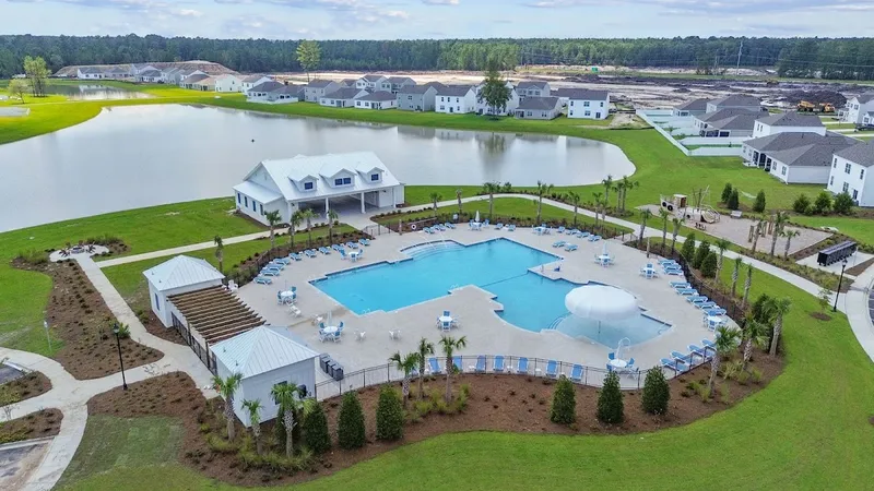 Pool, clubhouse and lake with new homes behind them at The Retreat at East Argent