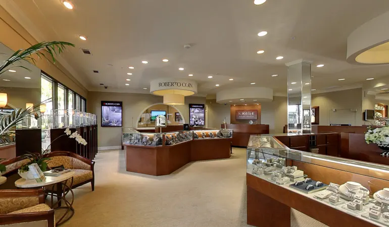 The Forsythe Jewelers showroom, with glass display cases of jewelry and warm wood counters under recessed lighting