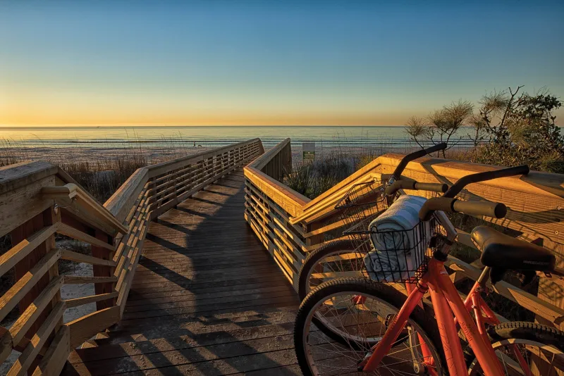 Marriott’s Monarch at Sea Pines beach boardwalk at sunrise, with a resort bike parked at the entrance