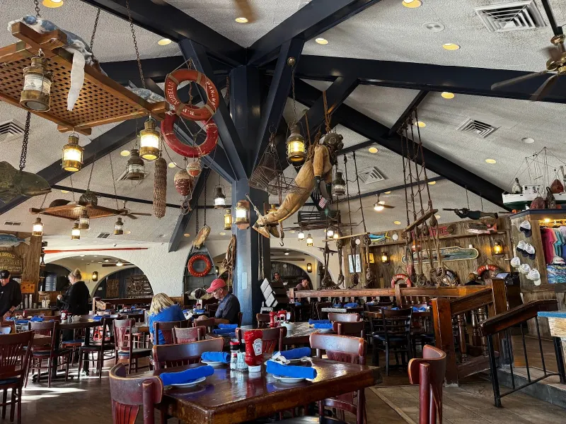 The dining room at the Crazy Crab in Harbour Town, with brass lanterns, life rings and a vintage diving suit hanging from the beams