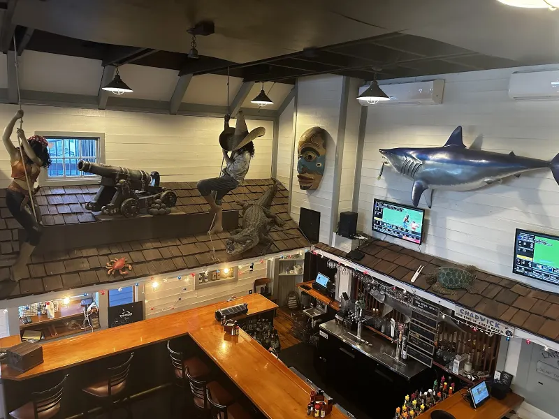 The wooden bar inside Land’s End Tavern at South Beach Marina, with nautical decor on the walls