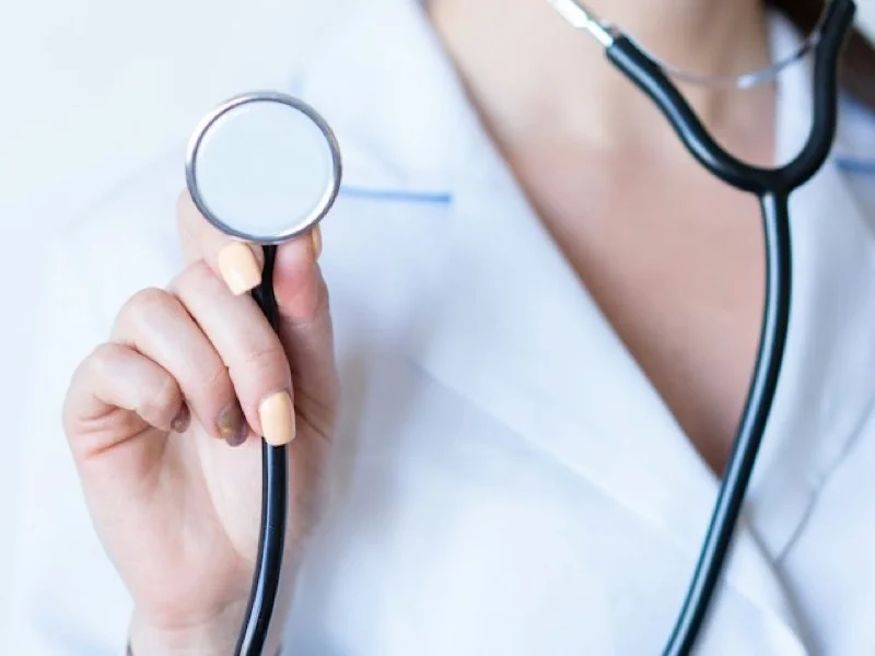 A doctor in a white coat holding a stethoscope
