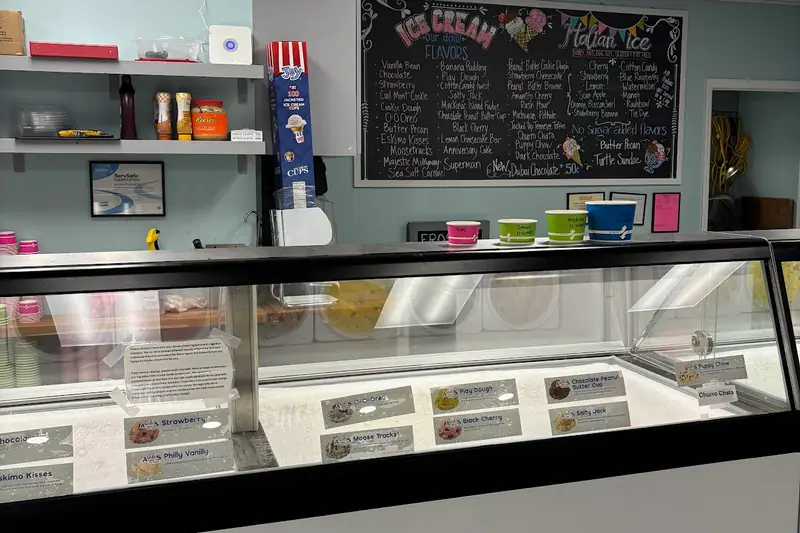 The ice cream counter at Frosty’s, with the dipping cabinet and a chalkboard flavor list on the wall