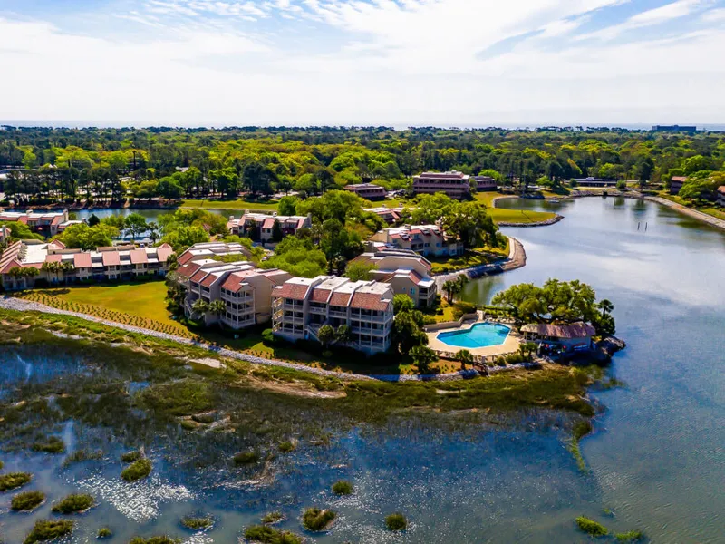 The Peninsula at Newport townhouses and pool from the air, on a point between the marsh and a lagoon