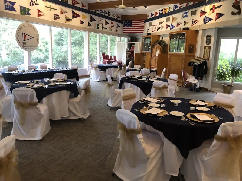 The clubhouse dining room at the Yacht Club of Hilton Head Island, with signal flags along the ceiling