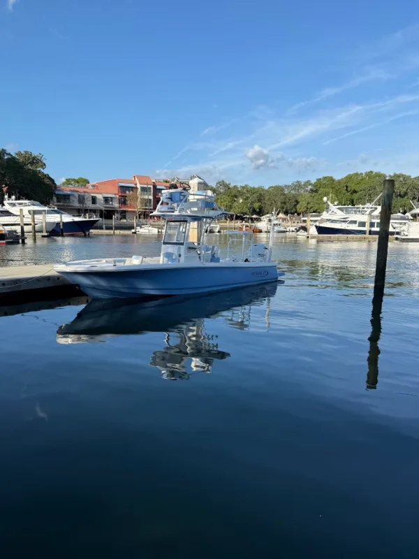The Aquatica Fishing Charters boat on calm water by a marina